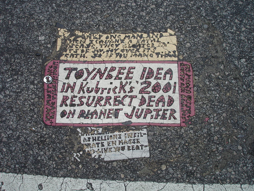 1024px-Toynbee_tile_in_crosswalk_at_intersection_of_13th_and_Market_streets_Philadelphia
